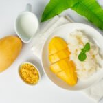 dalam gambar ini ialah pulut mangga dengan sebiji mangga kuning dan santan